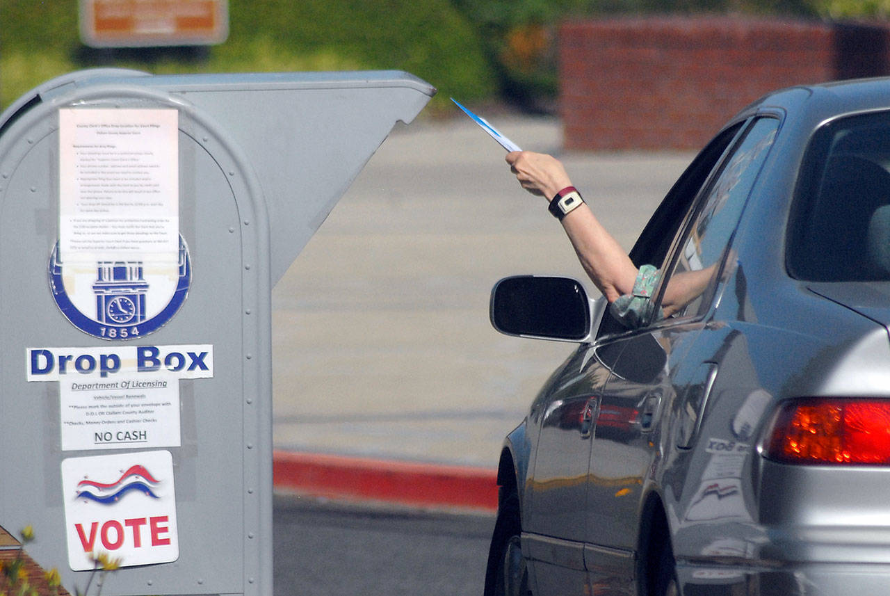 A motorist places a primary election ballot into a drop box outside the Clallam County Courthouse in Port Angeles on Tuesday, Aug. 4, 2020. (Keith Thorpe/Peninsula Daily News)