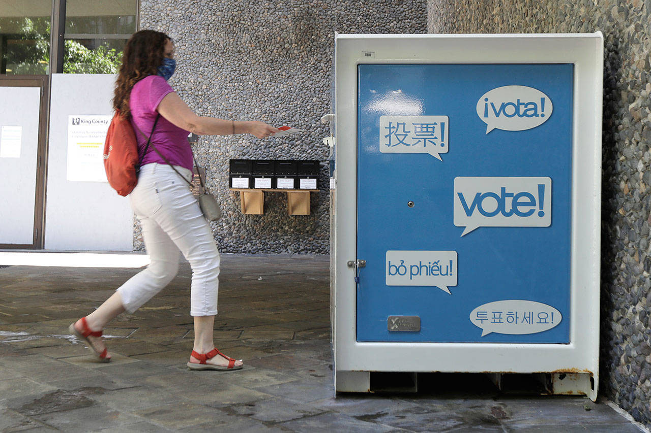 A person drops off a ballot for Washington state’s primary election Tuesday, Aug. 4, 2020, at a collection box at the King County Administration Building in Seattle. Voters in the state have the option of voting by mail, depositing ballots in boxes, or seeking help in person for a missing ballot or other issues. (Ted S. Warren/Associated Press)