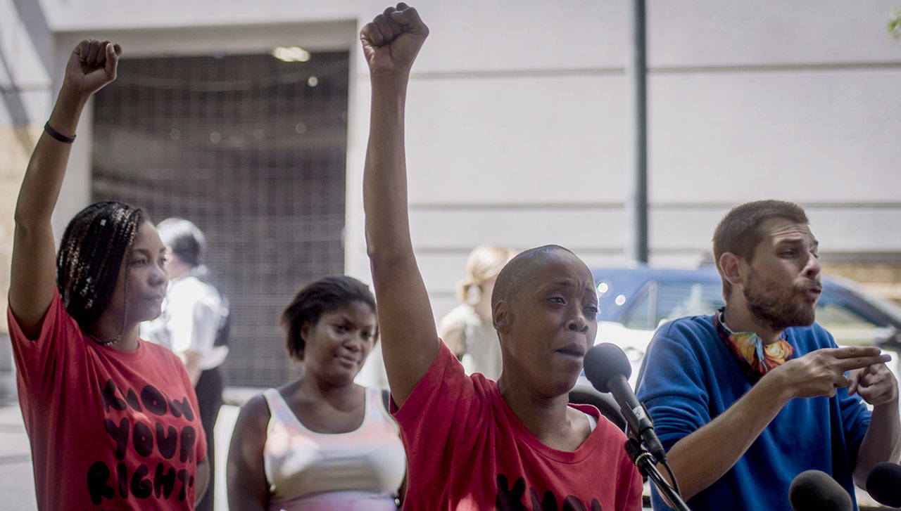 Demetria Hester, center, speaks to the media after being released from the Multnomah County Justice Center on Monday, Aug. 10, 2020, in Portland, Ore. Hester became a leading activist in the racial justice movement after she was assaulted by a white supremacist three years ago. Authorities said Hester wont be charged following her arrest early Monday. Hester had been booked on suspicion of disorderly conduct and interfering with a police officer during the protest that began Sunday night. Hesters arrest drew a sharp rebuke from national Black Lives Matter activists, who are increasingly focusing on demonstrations in Oregons largest city. (Brooke Herbert/The Oregonian via AP)