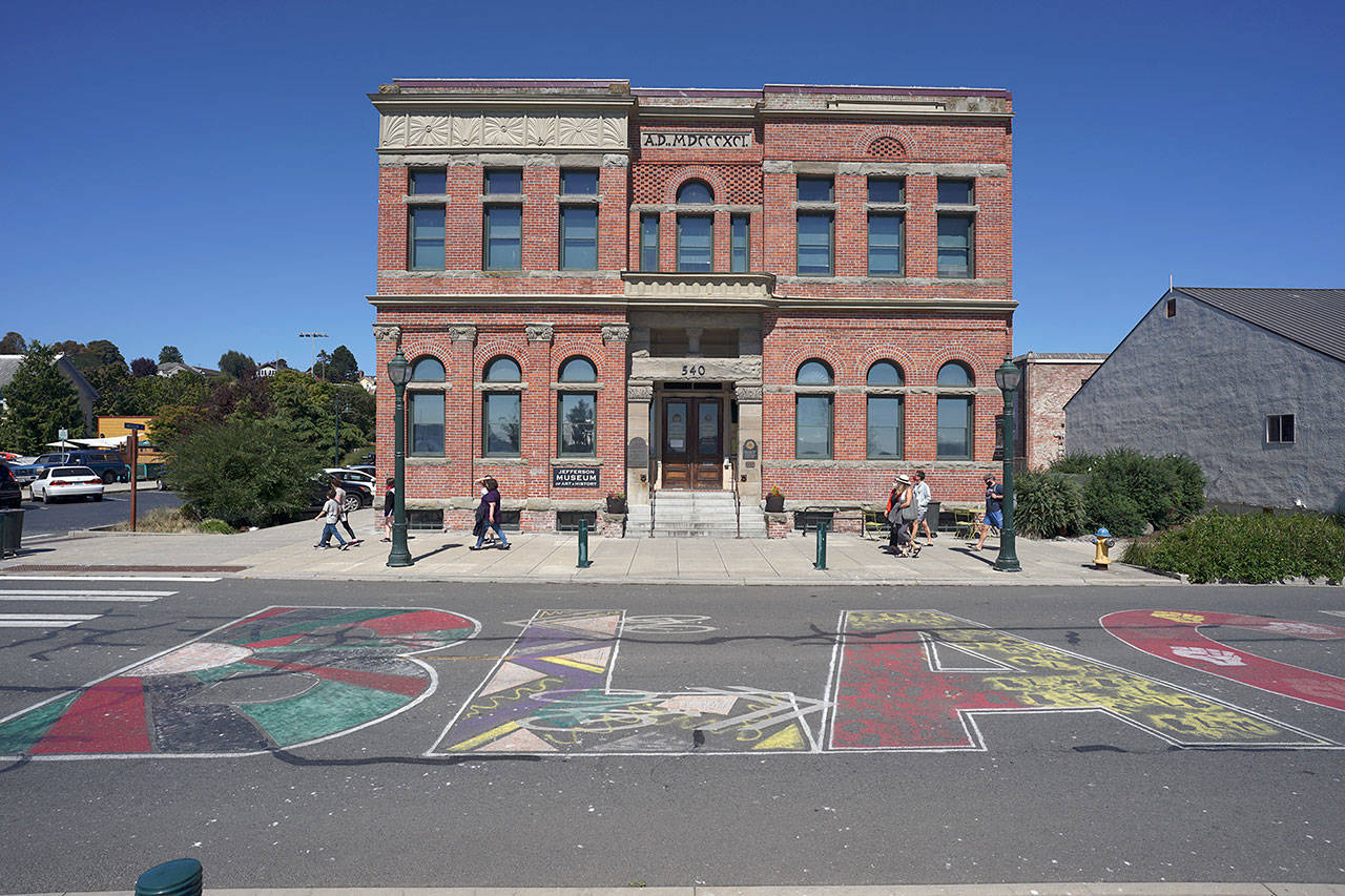 People walk past the Black Lives Matter mural painted along Water Street between City Hall and Pope Marine Park in downtown Port Townsend on Friday afternoon. The mural was created June 19 using water-based aerosol paint meant for marking pavement and expected to last as long as four months. (Nicholas Johnson/Peninsula Daily News)