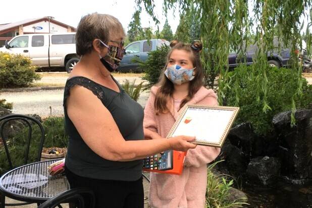 Ten-year-old Chloe Dunn of Port Angeles won an Amazon Fire tablet from the Clallam County Literacy Council for winning in her age bracket in the group’s writing contest. Here the group’s chairperson Philomena Lund presents a certificate and table to Dunn. (Submitted photo)