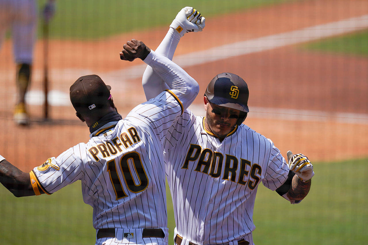 San Diego Padres’ Manny Machado, right, reacts with teammate Jurickson Profar (10) after hitting a home run during the fourth inning of a baseball game against the Seattle Mariners on Thursday, Aug. 27, 2020, in San Diego. (Gregory Bull/Associated Press)