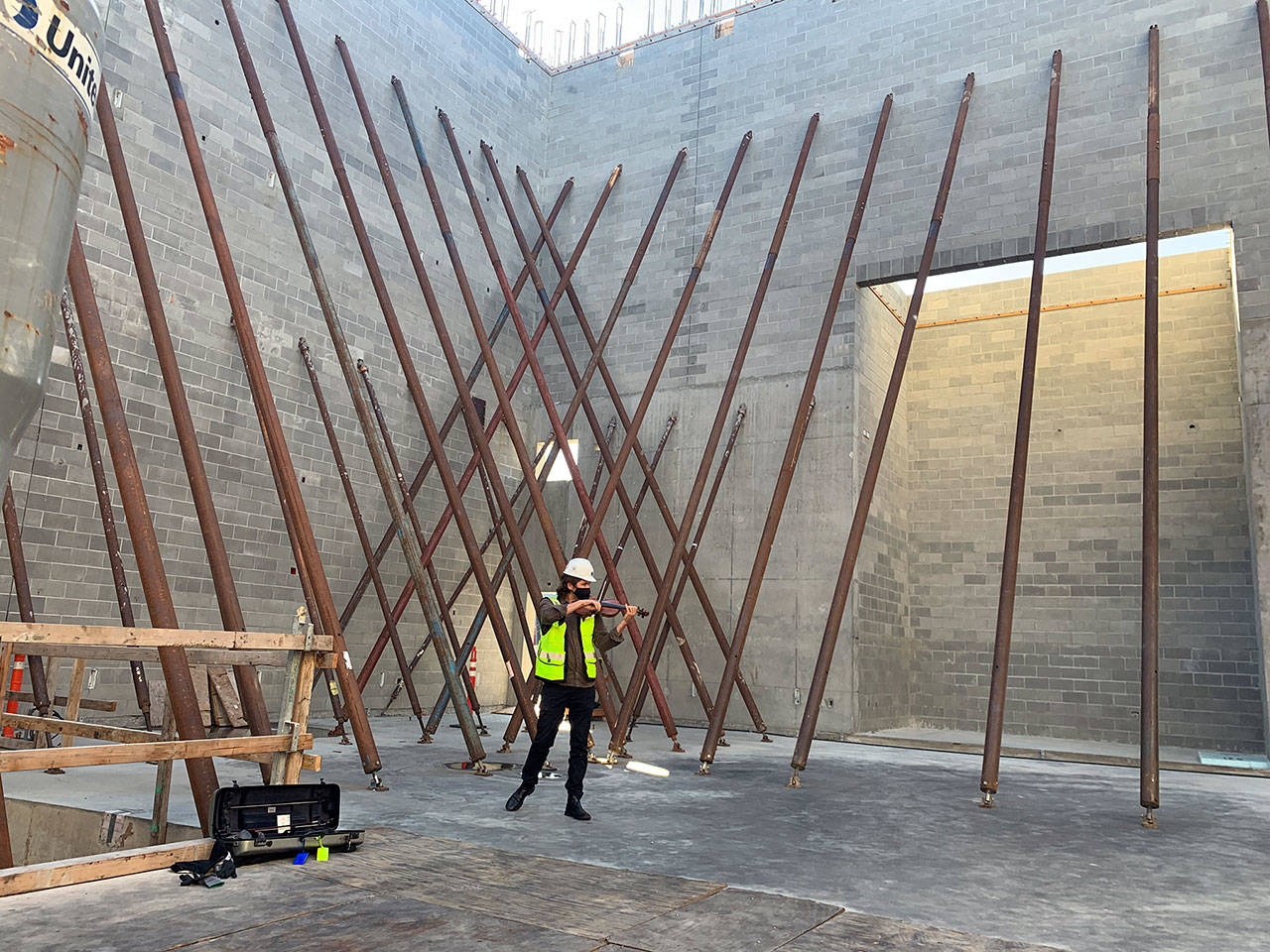 Port Angeles-bred musician James Garlick tests the sound inside the Field Arts & Events Hall. He and violist Richard O’Neill will give a performance as part of the building’s topping-off ceremony, to be streamed online Wednesday. (Photo courtesy of Austin Buchholz)