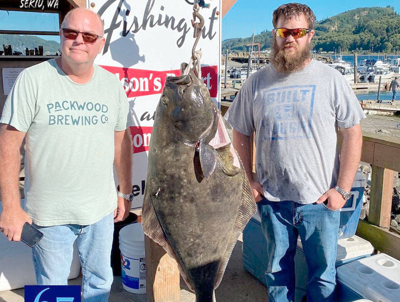 Alex Desseau, right, caught this 67-pound halibut while fishing out of Sekiu last week. Glenn Desseau is at left. The Desseau’s also limited out on coho during their trip. (Mason’s Resort)