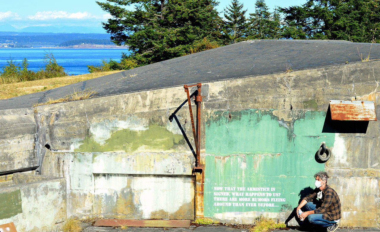 Artist Aaron Asis finished stenciling 23 historical quotations onto Fort Worden’s battery walls this past week. His favorite is a wartime question: “Now that the armistice is signed, what happens to us? There are more rumors flying around than ever before.” (Photo by Diane Urbani de la Paz/for Peninsula Daily News)