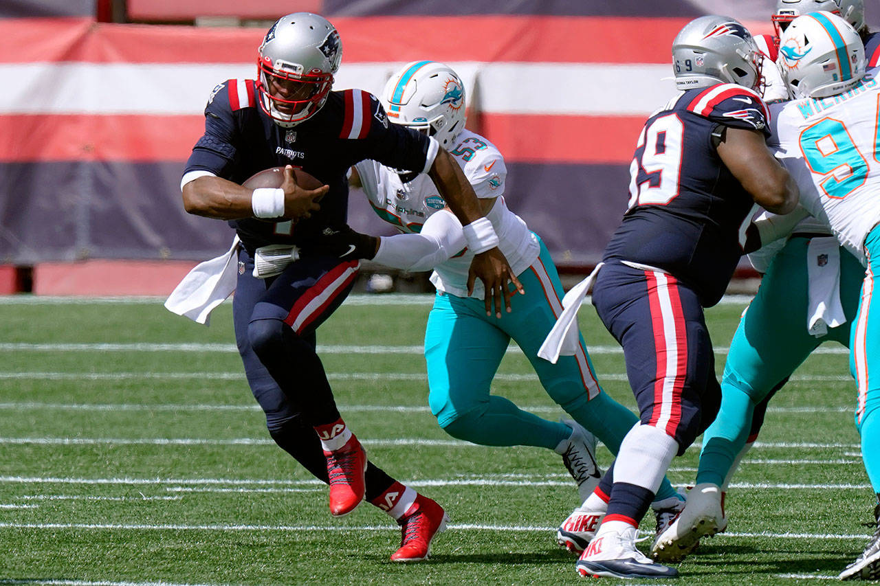 New England Patriots quarterback Cam Newton, front, runs from Miami Dolphins linebacker Kyle Van Noy (53) in the first half of an NFL football game Sunday, Sept. 13, 2020, in Foxborough, Mass. (Steven Senne/Associated Press)