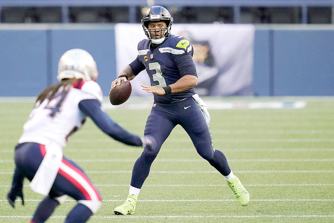 Seattle Seahawks quarterback Russell Wilson looks to pass against the New England Patriots during the first half of an NFL football game, Sunday, Sept. 20, 2020, in Seattle. (AP Photo/Elaine Thompson)