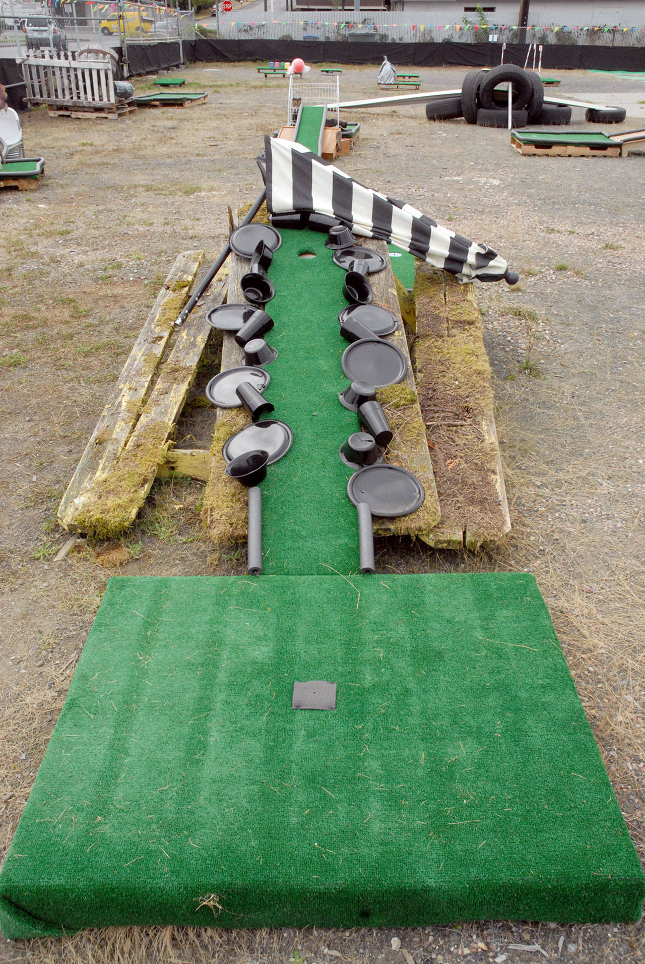 Plastic plates and cups and an old picnic table make up a miniature golf hole at OMG Olympic Miniature Golf in Port Angeles. (Keith Thorpe/Peninsula Daily News)