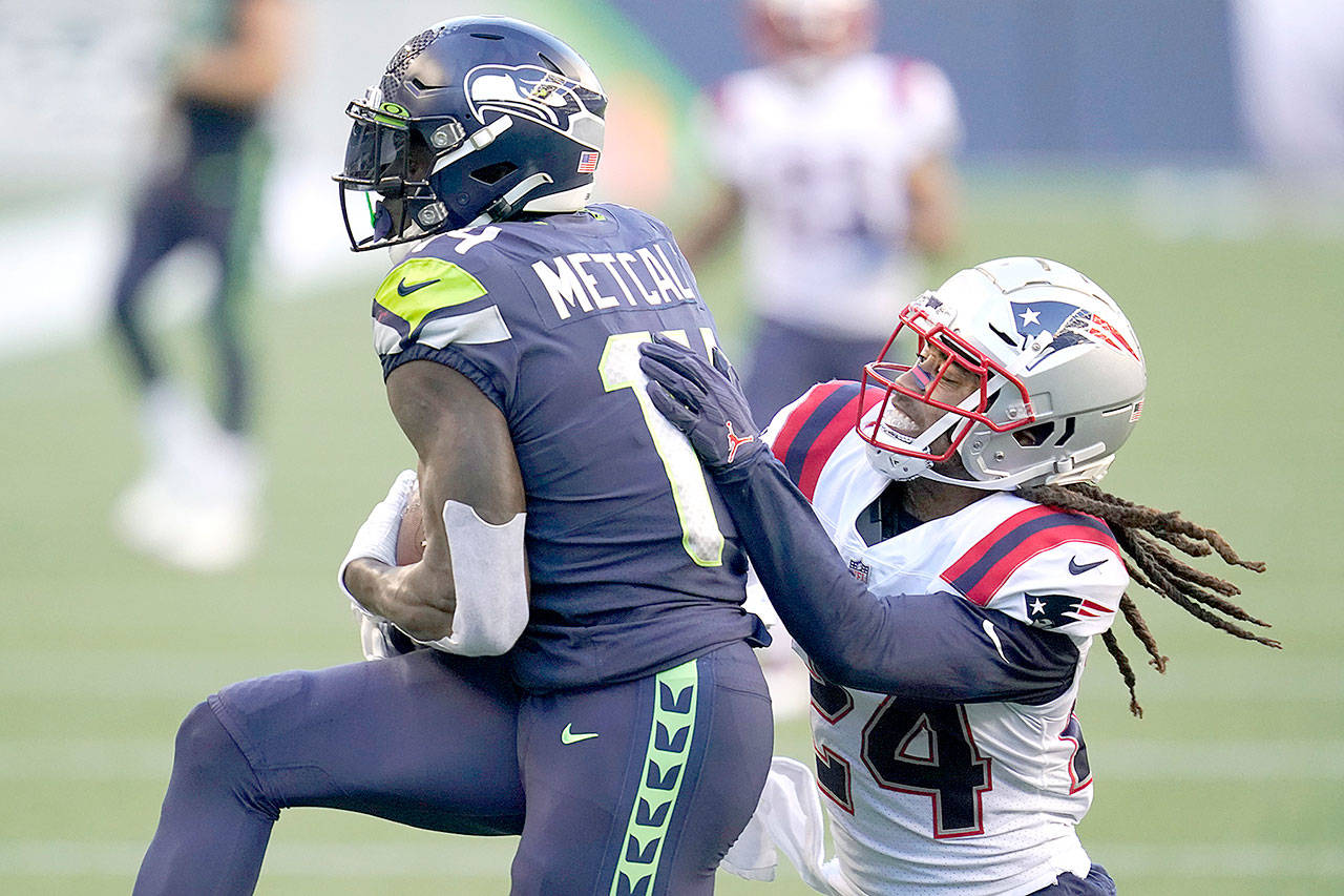 Seattle Seahawks wide receiver DK Metcalf, left, catches a pass for a touchdown as New England Patriots cornerback Stephon Gilmore defends Sunday in Seattle. (Elaine Thompson/Associated Press)