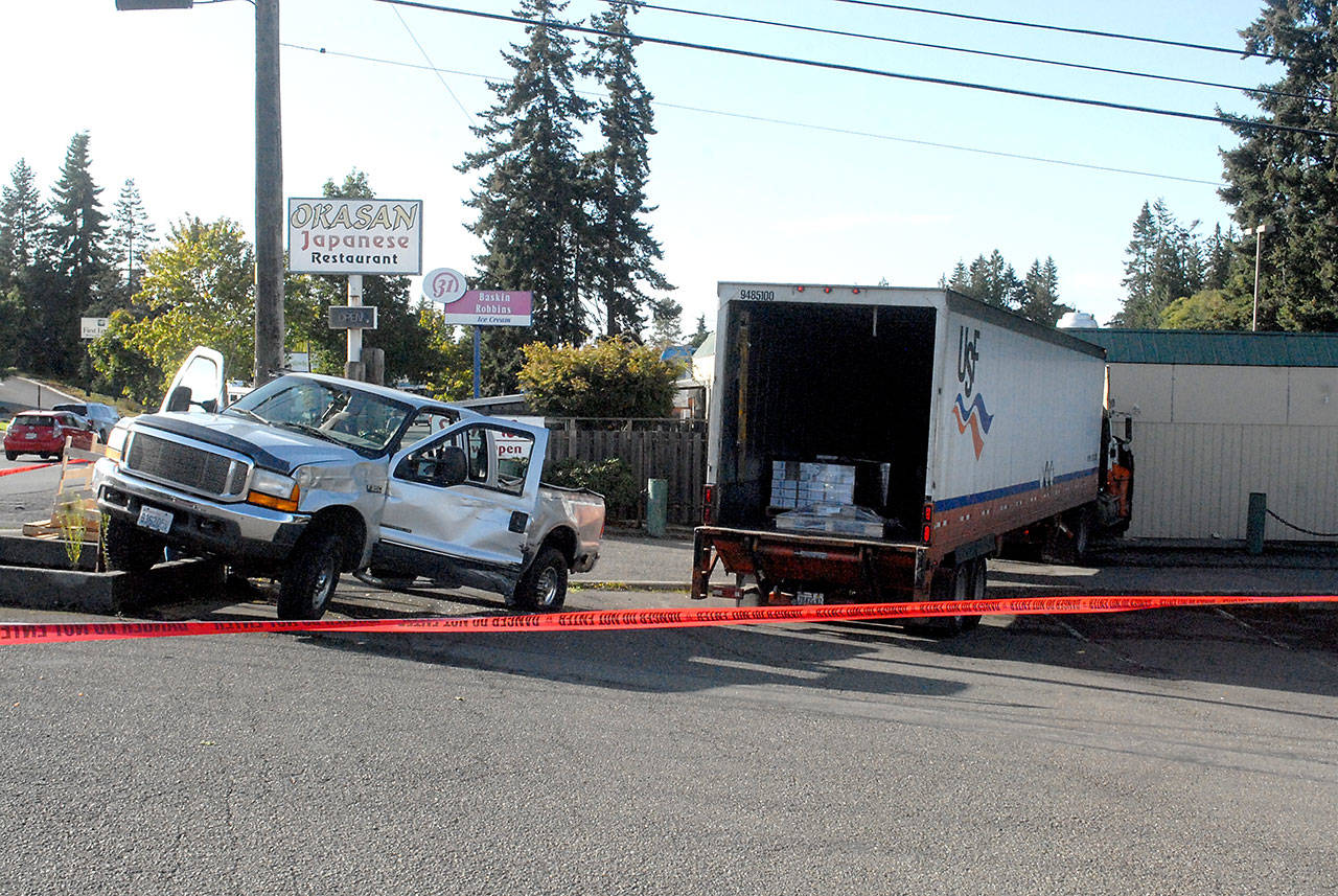 A pickup truck sits behind caution tape after it was struck by a runaway semi-trailer in Port Angeles. (Keith Thorpe/Peninsula Daily News)
