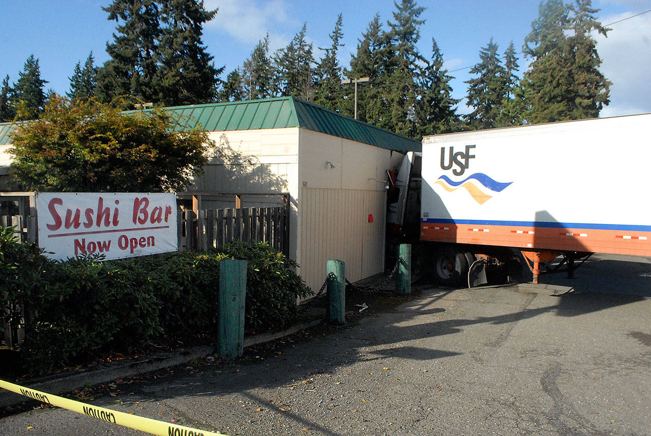 A semi-trailer pokes out from the side of Okasan Japanese Restaurant in Port Angeles after the driverless vehicle rolled into a nearby parked pickup truck and careened into the restaurant Friday, Sept. 25, 2020. (Keith Thorpe/Peninsula Daily News)