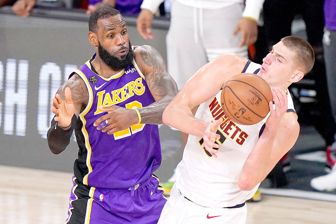 Los Angeles Lakers’ LeBron James (23) and Denver Nuggets’ Nikola Jokic (15) battle for the ball during the second half of an NBA conference final playoff basketball game Saturday in Lake Buena Vista, Fla. The Lakers won 117-107 to win the series 4-1. (AP Photo/Mark J. Terrill)