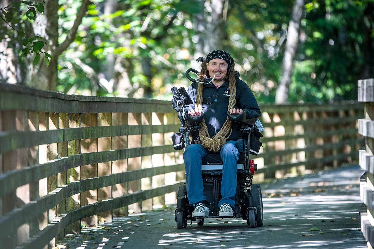 Ian Mackay, executive director of Ian’s Ride, rides his powered wheelchair on the Olympic Discovery Trail near Port Angeles last month. (Jesse Major/Ian’s Ride)