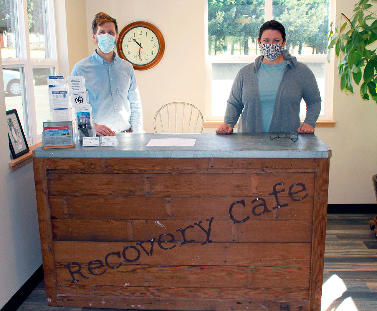 Recovery Cafe Program Manager Brian Richardson, left, along with volunteer and advisory committee member Maura Walsch, stand behind the welcome desk of the Recovery Cafe on Tuesday as the pair and other volunteers worked to finish the last pieces of the cafe’s renovations. (Zach Jablonski/Peninsula Daily News)