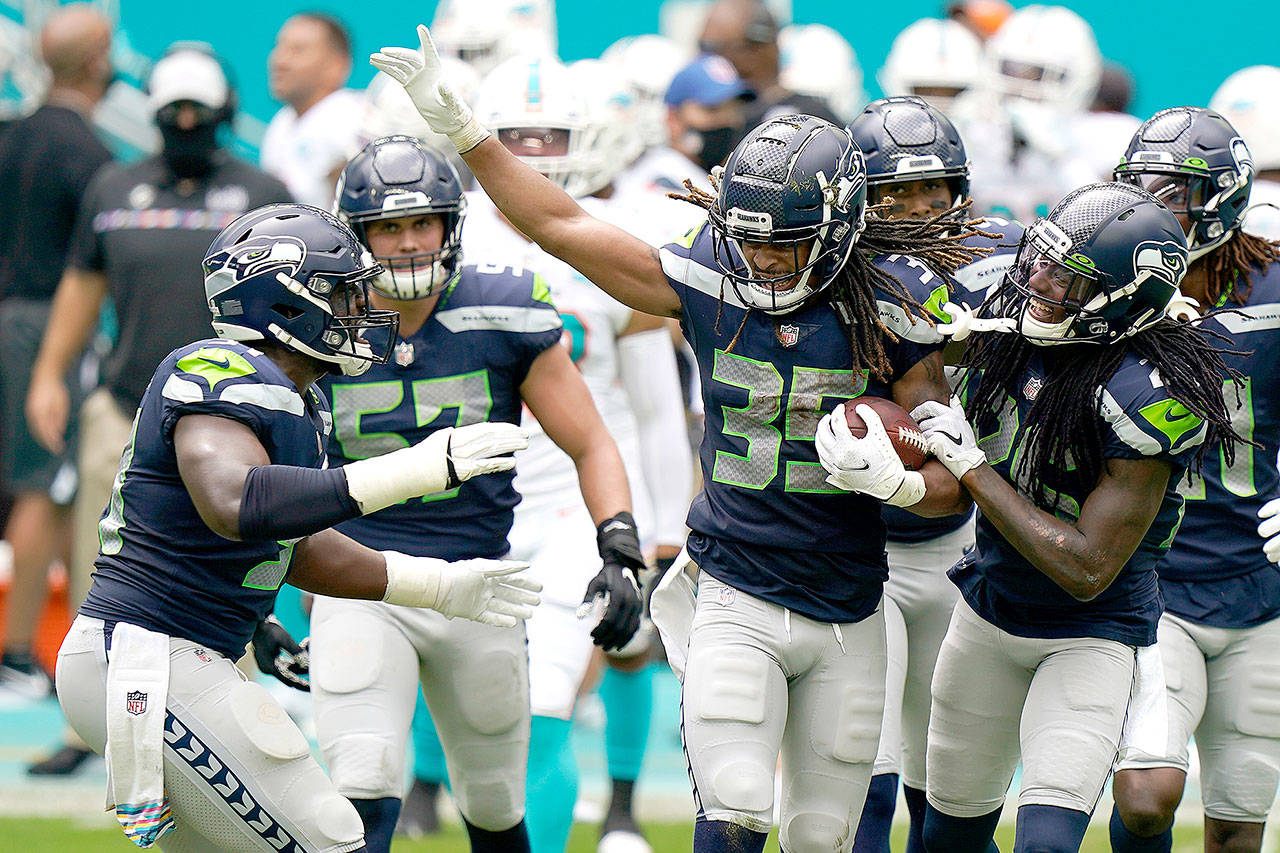 Seattle Seahawks cornerback Ryan Neal (35) is celebrated by his teammates after intercepting a pass against the Miami Dolphins on Sunday in Miami Gardens, Fla. (Wilfredo Lee/The Associated Press)