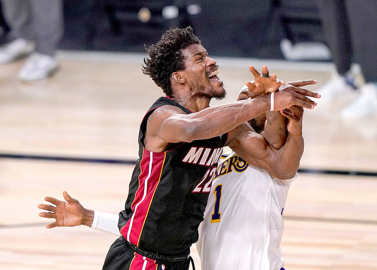 Miami Heat’s Jimmy Butler (22) is fouled Sunday by Los Angeles Lakers’ Kentavious Caldwell-Pope (1) during Game 3 of the NBA Finals in Lake Buena Vista, Fla. (Mark J. Terrill/Associated Press)