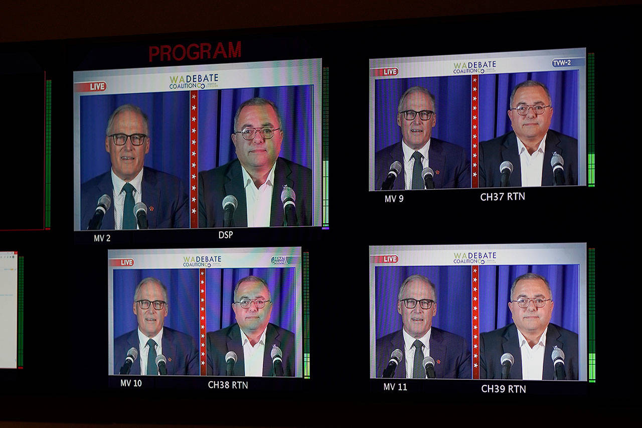 Washington gubernatorial candidates Gov. Jay Inslee, a Democrat, left, and Loren Culp, a Republican, right, are shown on a monitor in a video control room at the studios of TVW, Wednesday, Oct. 7, 2020, in Olympia, Wash., as they take part in a debate. Due to concerns over COVID-19, each candidate took part in the debate from individual rooms separate from moderators. (Ted S. Warren/Associated Press)