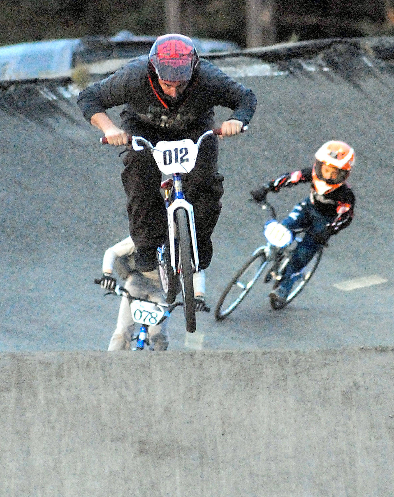 Keith Thorpe/Peninsula Daily News Aaron Petersen (012) of Port Angeles leads Sam Brown (078) of Port Angeles in the novice category at the Lincoln Park BMX Track on Thursday night under the track’s new lights. The track is back open for competition.