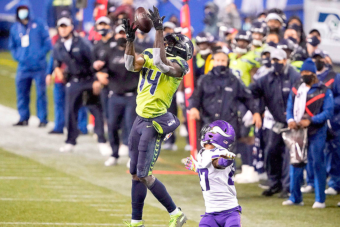 Seattle Seahawks' DK Metcalf (14) pulls in a long pass reception on the Seahawks' last series of an NFL football game as Minnesota Vikings' Cameron Dantzler defends late in the second half, Sunday, Oct. 11, 2020, in Seattle. The Seahawks won 27-26. (AP Photo/Ted S. Warren)