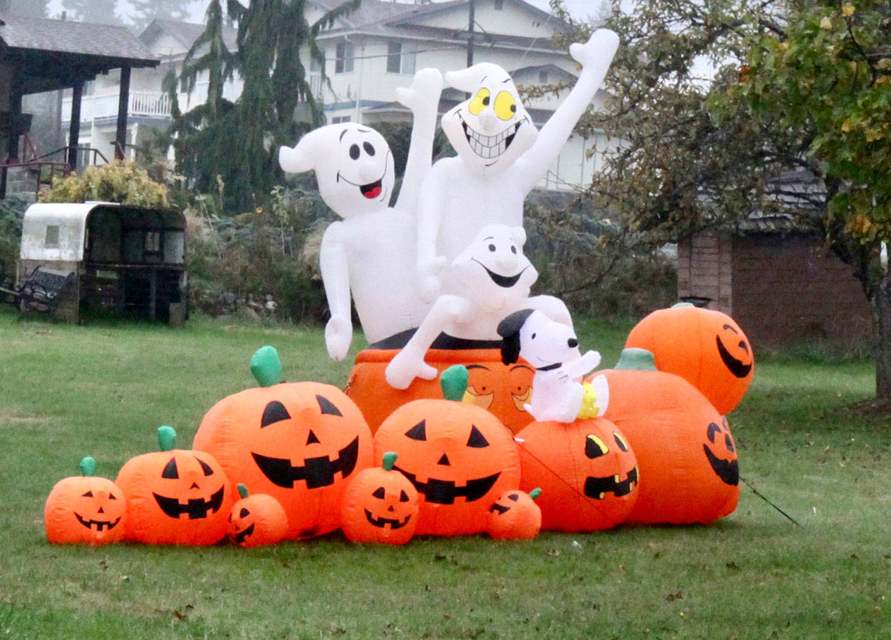 Happy ghosts hop out of a pile of pumpkins and smile in an open lot at 12th and C streets in west Port Angeles. (Dave Logan/for Peninsula Daily News)