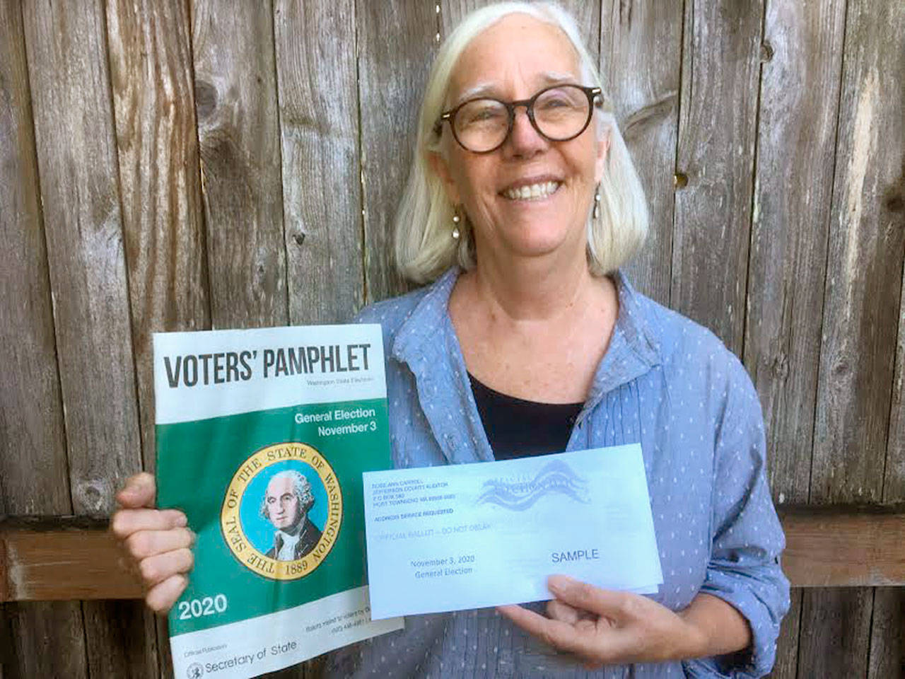 Janette Force, executive director of the Port Townsend Film Festival, holds a sample ballot and a state-produced Voters’ Pamphlet. (Submitted photo)