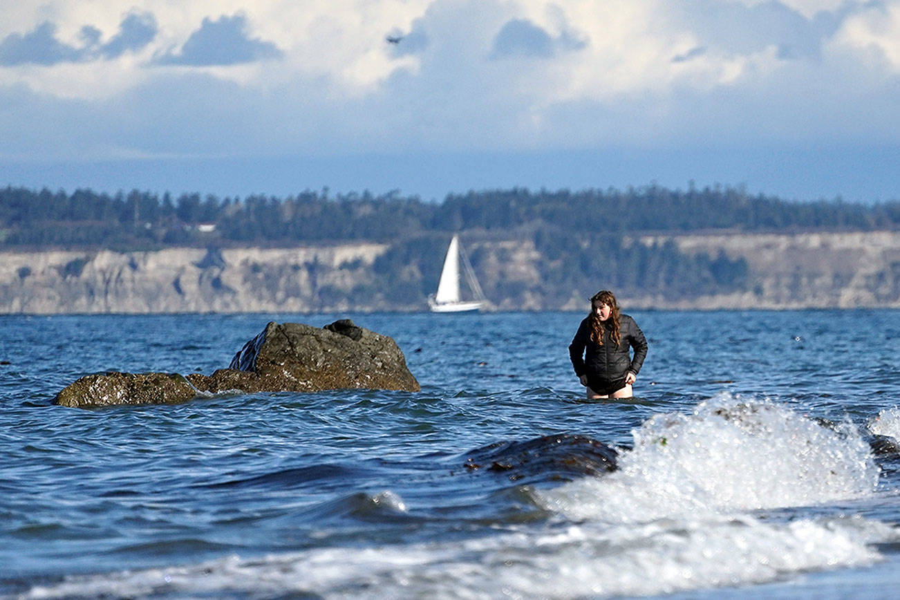 Aiming to observe fish as part of her marine biology studies, an eighth-grade student in Port Townsend's OCEAN alternative learning program walks through waves off North Beach County Park on a crisp, sunny October afternoon Wednesday. (Nicholas Johnson/Peninsula Daily News)