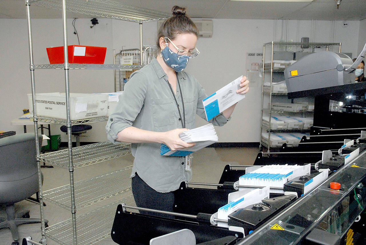 Clallam County election worker Nicole Mischke pulls sorted ballots from a sorting machine Wednesday, Oct. 21, 2020, at the county courthouse in Port Angeles. (Keith Thorpe/Peninsula Daily News)