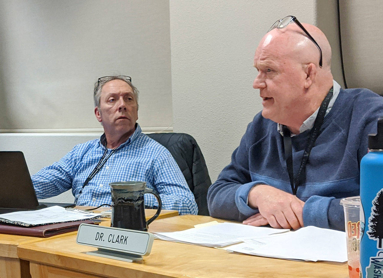 Sequim School District superintendent Rob Clark, right, discusses terms of his contract extension with the school board while board president Brandino Gibson listens on during a school board meeting in January. Clark is on leave as of Oct. 22 pending the outcome of a complaint, school district officials said this week. (Conor Dowley/Olympic Peninsula News Group file)