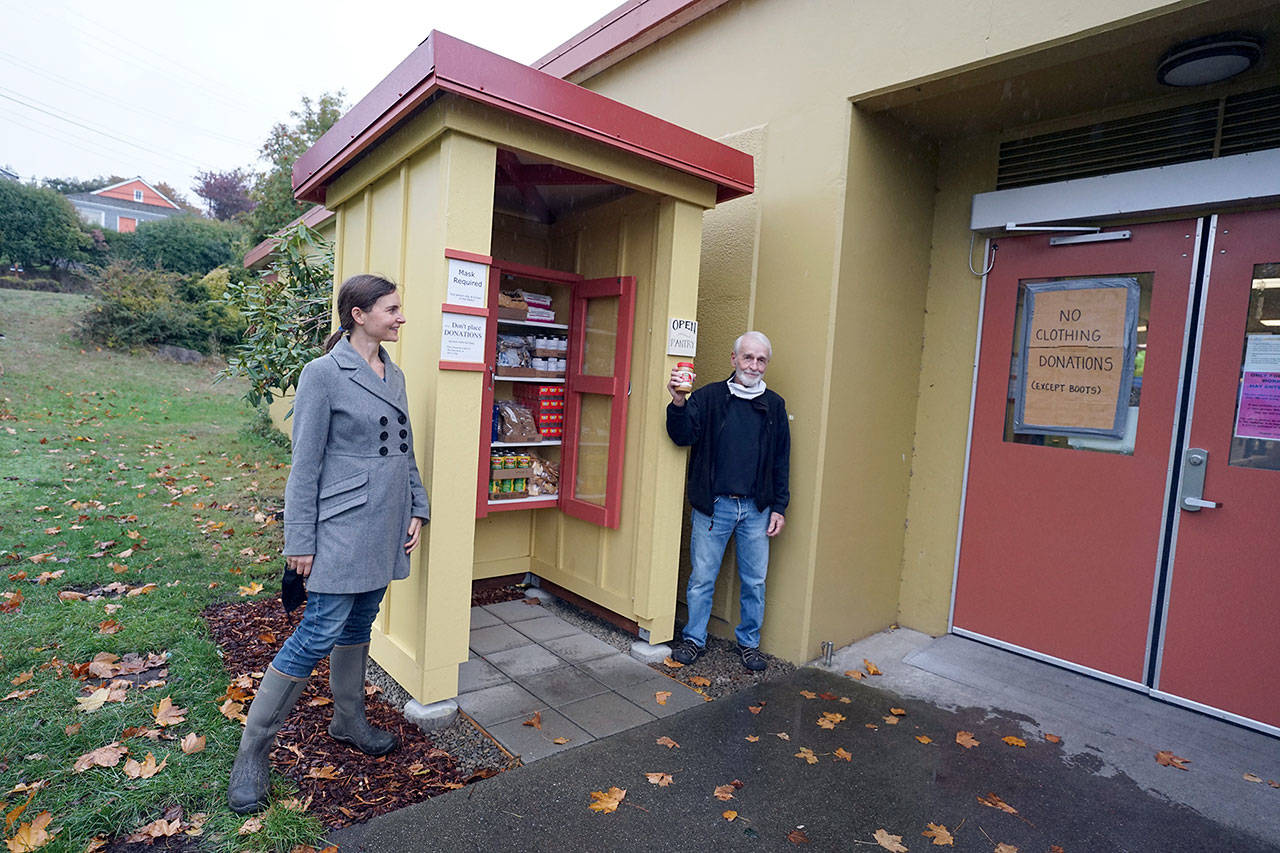 Lauren Ehnebuske, left, and Bob Wallace stand next to the food pantry that Ehnebuske designed and Wallace built outside the Port Townsend Food Bank. The pantry offers free non-perishable food items any time of day or night. (Nicholas Johnson/Peninsula Daily News)
