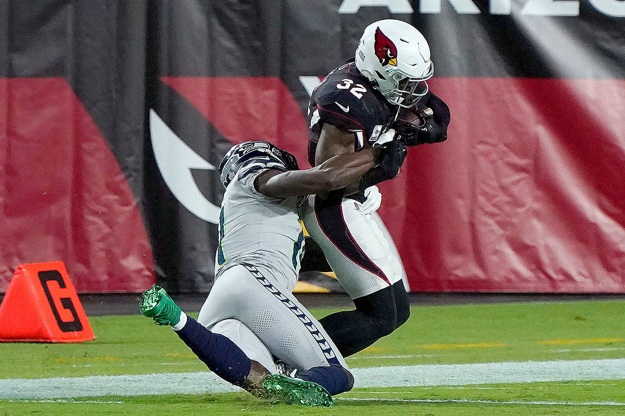 Seattle Seahawks wide receiver DK Metcalf tackles Arizona Cardinals strong safety Budda Baker (32) short of the goal line after Baker intercepted a pass during the first half of an NFL football game Sunday, Oct. 25, 2020, in Glendale, Ariz. (Rick Scuteri/Associated Press)