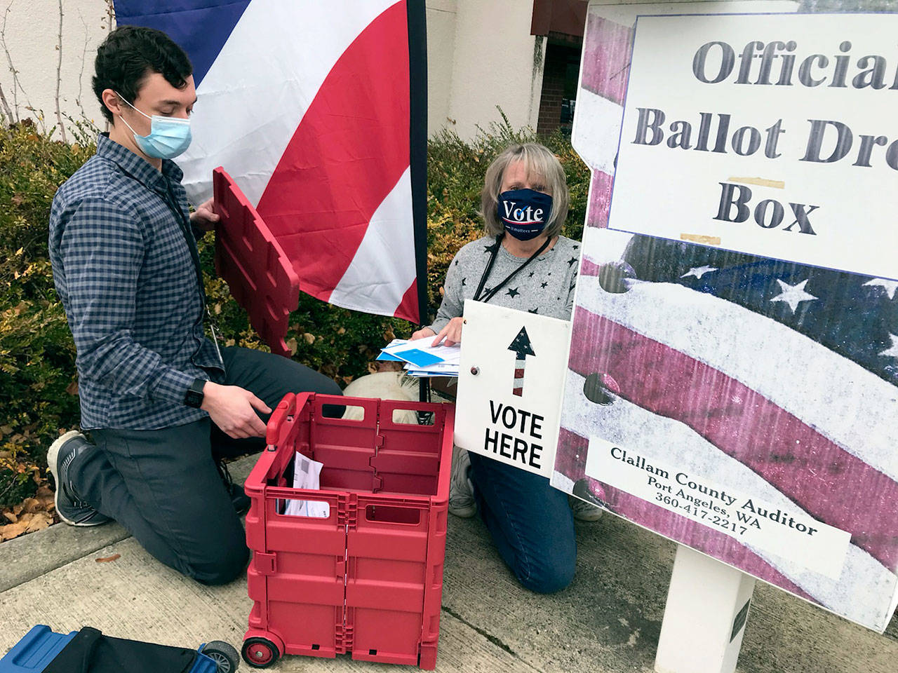 Clallam County election workers Ame Cochnauer, right, and Thomas Newton did their second of at least three ballot pickups Monday, Oct. 26, 2020, from two drop boxes outside the Clallam County Courthouse that hold a combined 1,200 ballots. (Paul Gottlieb/Peninsula Daily News)