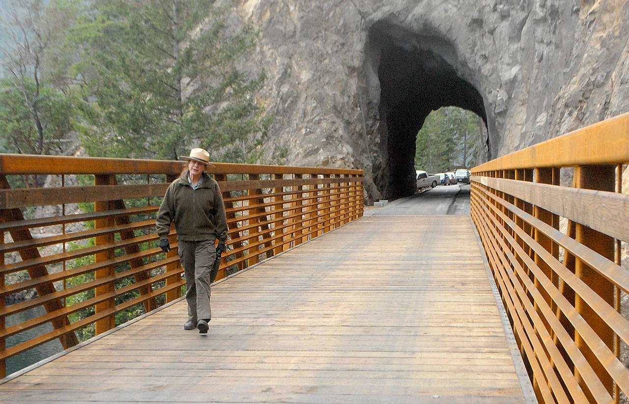 Olympic National Park Superintendent Sarah Creachbaum walks across a new bridge on the Spruce Railroad Trail abutting the recently renovated Daley-Rankin Tunnel at the start of a ceremony on Thursday to celebrate the soon-to-be-open trail on the north shore of Lake Crescent. (Keith Thorpe/Peninsula Daily News)