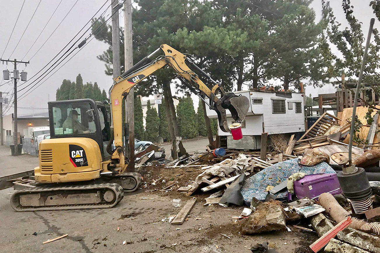 Paul Gottlieb/Peninsula Daily News
Jim Bishop operated an excavator Monday on property being cleaned up on orders from Port Angeles city officials and owned by former Judge Brian Coughenour.