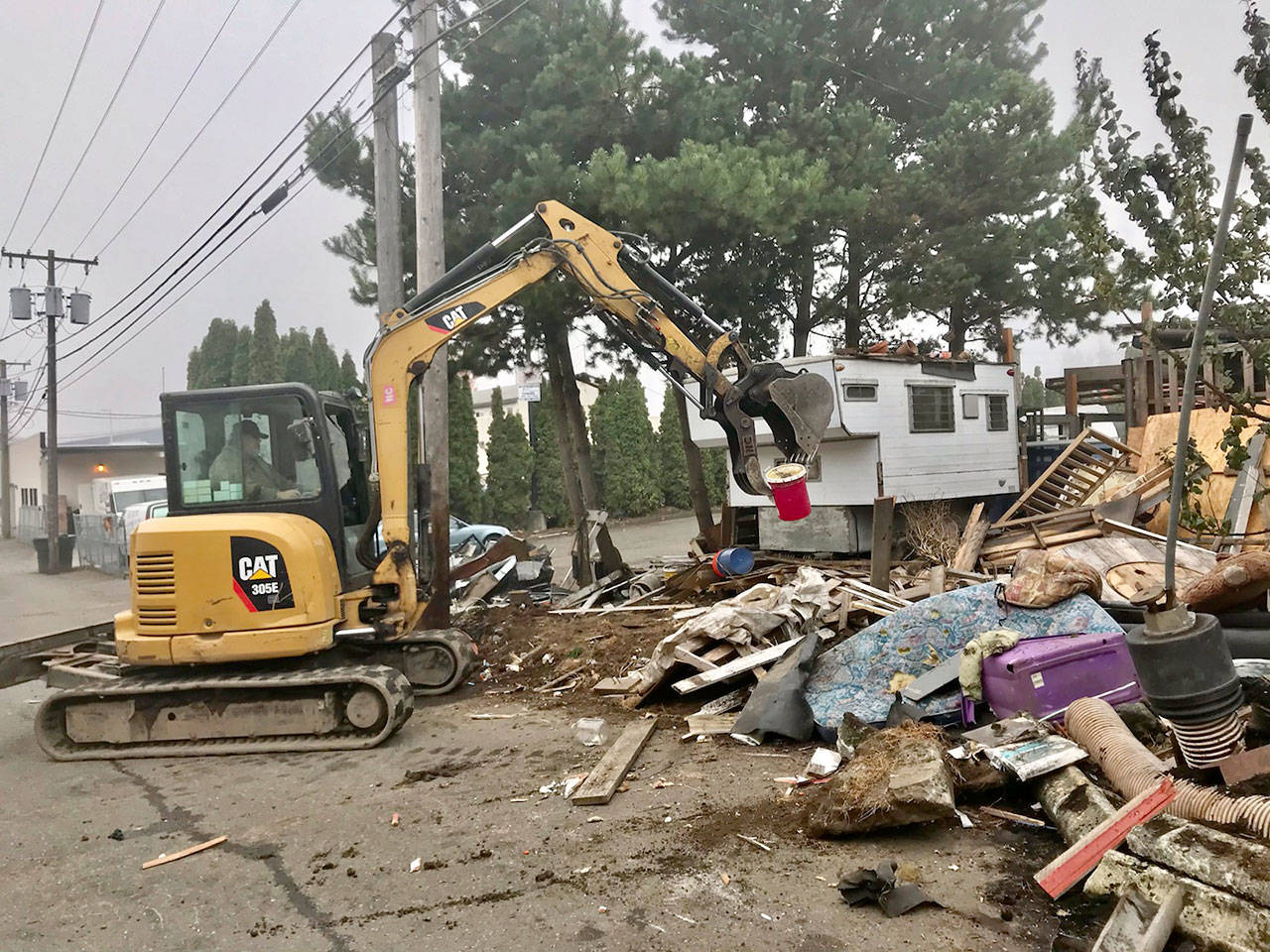 Jim Bishop operates an excavator Monday, Nov. 2, 2020, on property being cleaned up on orders from Port Angeles city officials. The property is owned by former Judge Brian Coughenour. (Paul Gottlieb/Peninsula Daily News)