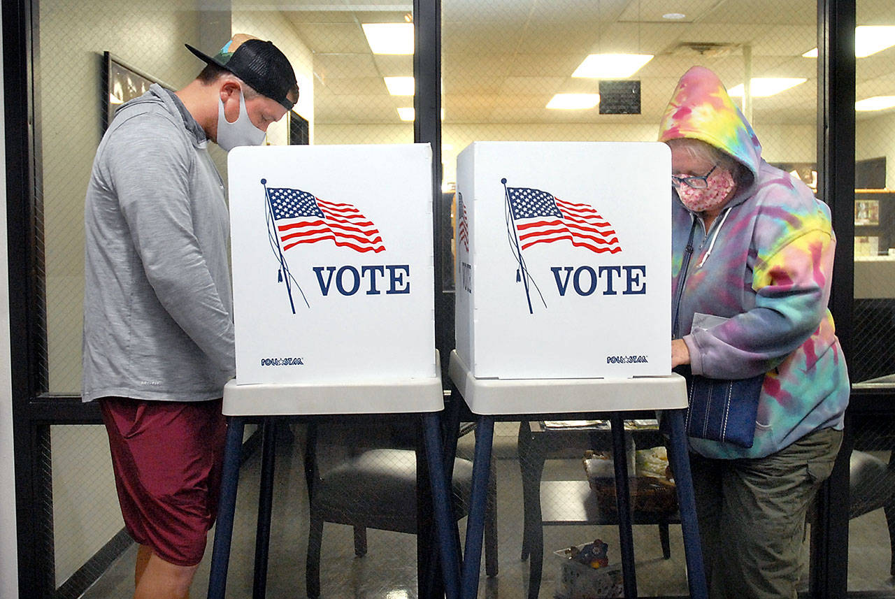 Danny Romero, left, and Petal Ruch, both of Port Angeles, fill out ballots at portable polling stations at the Clallam County Courthouse in Port Angeles on Election Day. (Keith Thorpe/Peninsula Daily News)