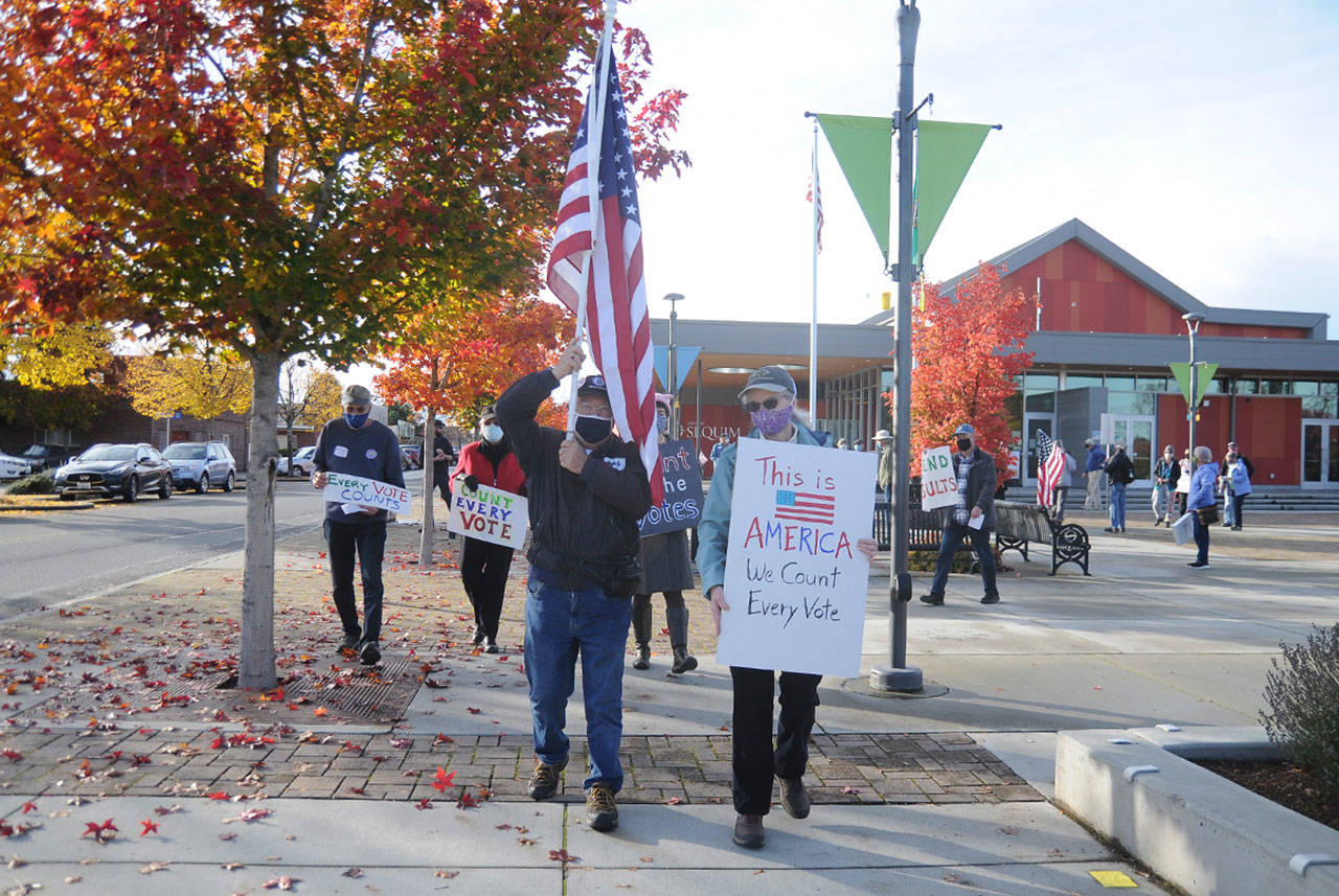Tim Wheeler and Lisa Dekker help lead a group of about 40 individuals in a rally and walk in downtown Sequim on Wednesday afternoon to promote the counting of all ballots in the 2020 general election. (Michael Dashiell/Olympic Peninsula News Group)