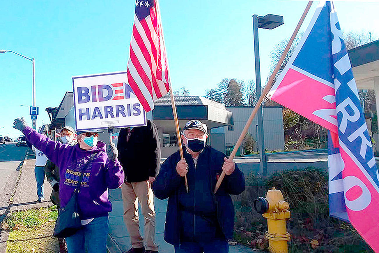 A group of about 25 supporters of Joe Biden and Kamala Harris held a rally at the corner of First and Lincoln streets in Port Angeles on Sunday to show their support for the president-elect. The group mostly had drivers honk at them in support though a couple of drivers shouted insults about Biden as they drove by. Biden was projected as the winner of the presidential election on Saturday by most news organizations, including The Associated Press. (Pierre LaBossiere/Peninsula Daily News)