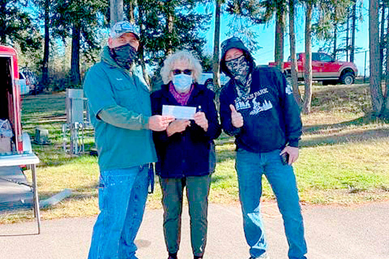 From left, Lincoln Park BMX Track operator Sean Coleman, Marsha Robin and Jason Groves show a check for $2,149 raised by the BMX track and riders fro the Port Angeles Food Bank for hte month of October. The track and riders also raised 360 pounds of food. The top earners were Bennett and Bradan Gray, first place, George Williams, second place and Cholena Morrison, third place.