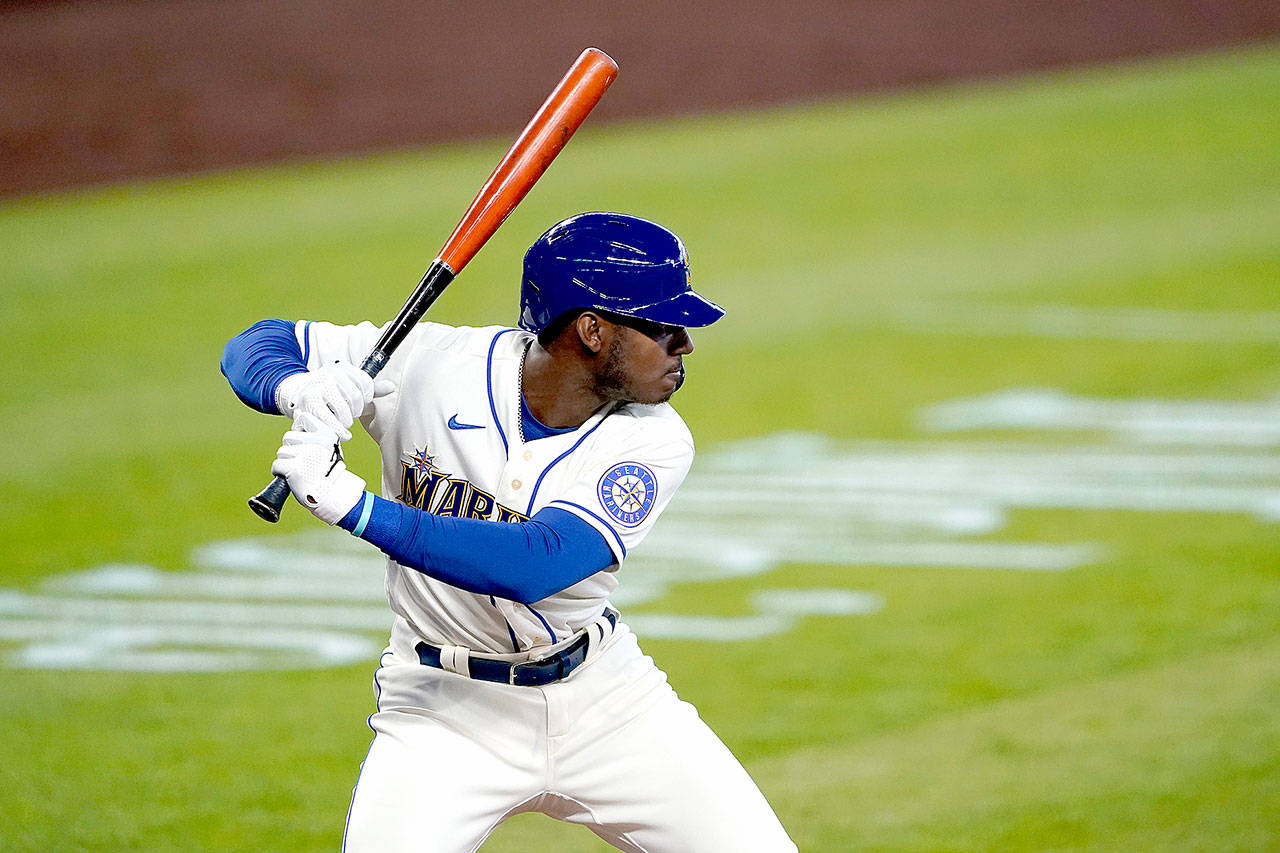The Seattle Mariners’ Kyle Lewis begins his swing on a solo home run against the Texas Rangers on Aug. 23. Lewis won the AL Rookie of the Year award on Monday, Nov. 9, 2020. (Ted S. Warren/Associated Press)