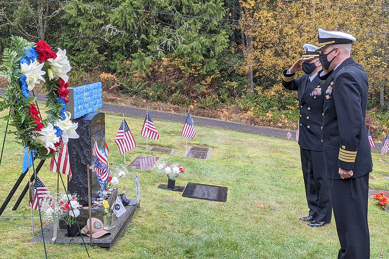 Naval Facilities Engineering Systems Command Northwest Executive Officer Capt. Angel Santiago, left, and Commanding Officer Capt. Ben Miller salute the grave of Medal of Honor recipient Navy Petty Officer Marvin G. Shields during the annual Veterans Day ceremony at the Gardiner Cemetery. The COVID-19 pandemic limited the ceremony to a small group of fewer than 10 people instead of the more than 100 who have attended in previous years. (Zach Jablonski/Peninsula Daily News)