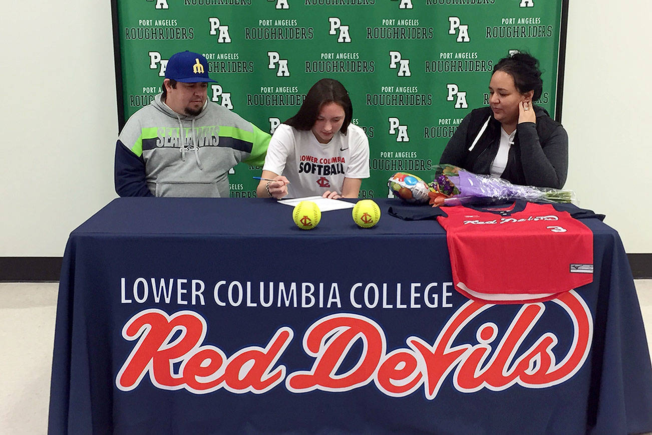 Port Angeles' Jada Cargo signs a letter of intent to play softball for Lower Columbia Community College. Cargo is joined by her stepdad Jeremy Acosta, left, and mother, Vashti White-Acosta.