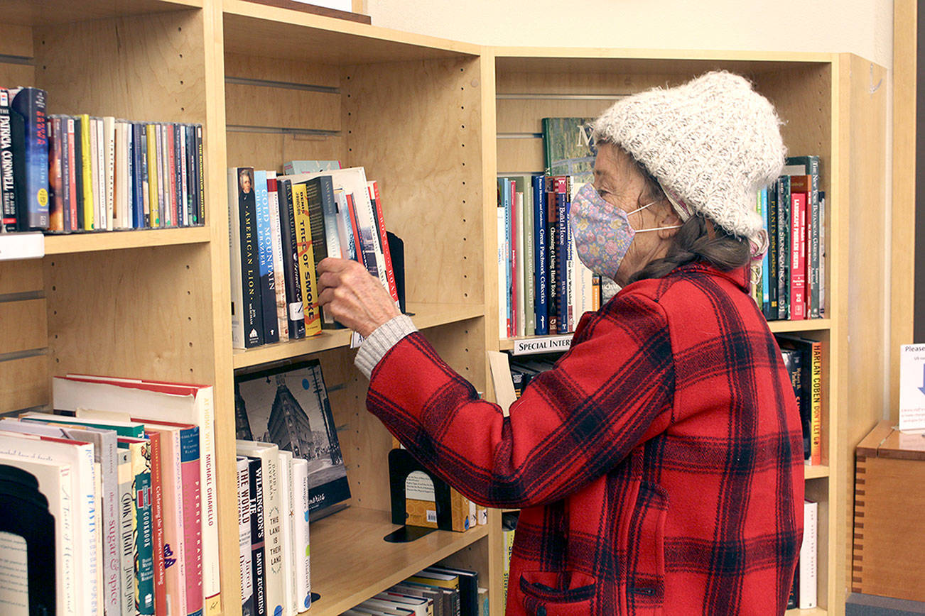 Pama O'Toole of Port Hadlock was in one of her favorite places as she browsed the books at the Jefferson County Library on Friday. The library has been open for in-person book checkout and other rentals when the county is in the state's low- and moderate-risk categories. The library also offers curbside pick and will continue to do so if it is required to close in-person visits due to rising case numbers of COVID-19. The Port Townsend Public Library hopes to open Tuesday with limited hours for checkout, depending on the county staying in the moderate-risk category. (Zach Jablonski/Peninsula Daily News)