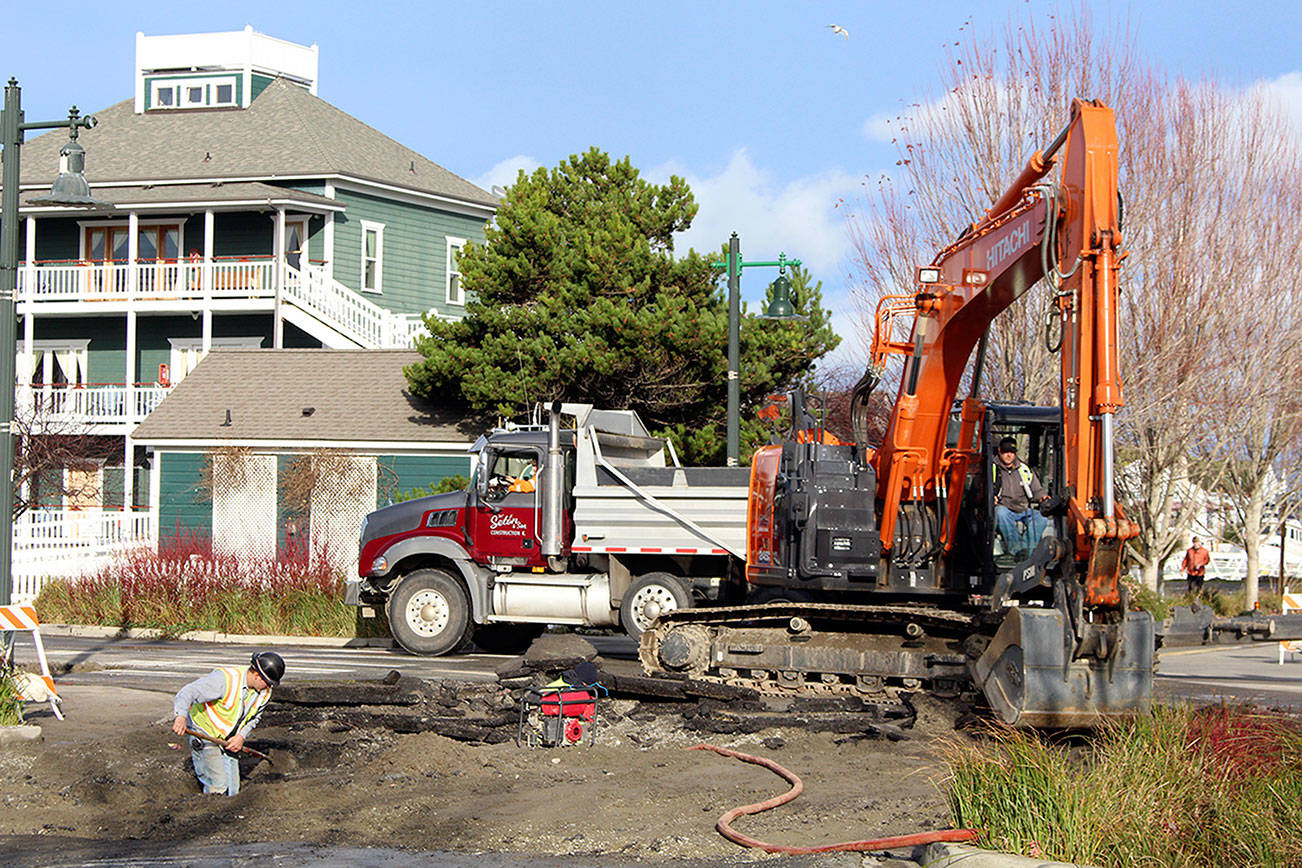 Teams from Port Townsend Public Works and Seton Construction work to uncover a water main that burst on the corner of Monroe and Water streets in Port Townsend Tuesday. The pipe burst Monday night, and Public Works Director Steve King estimated the repairs to take two to three days. (Zach Jablonski/Peninsula Daily News)