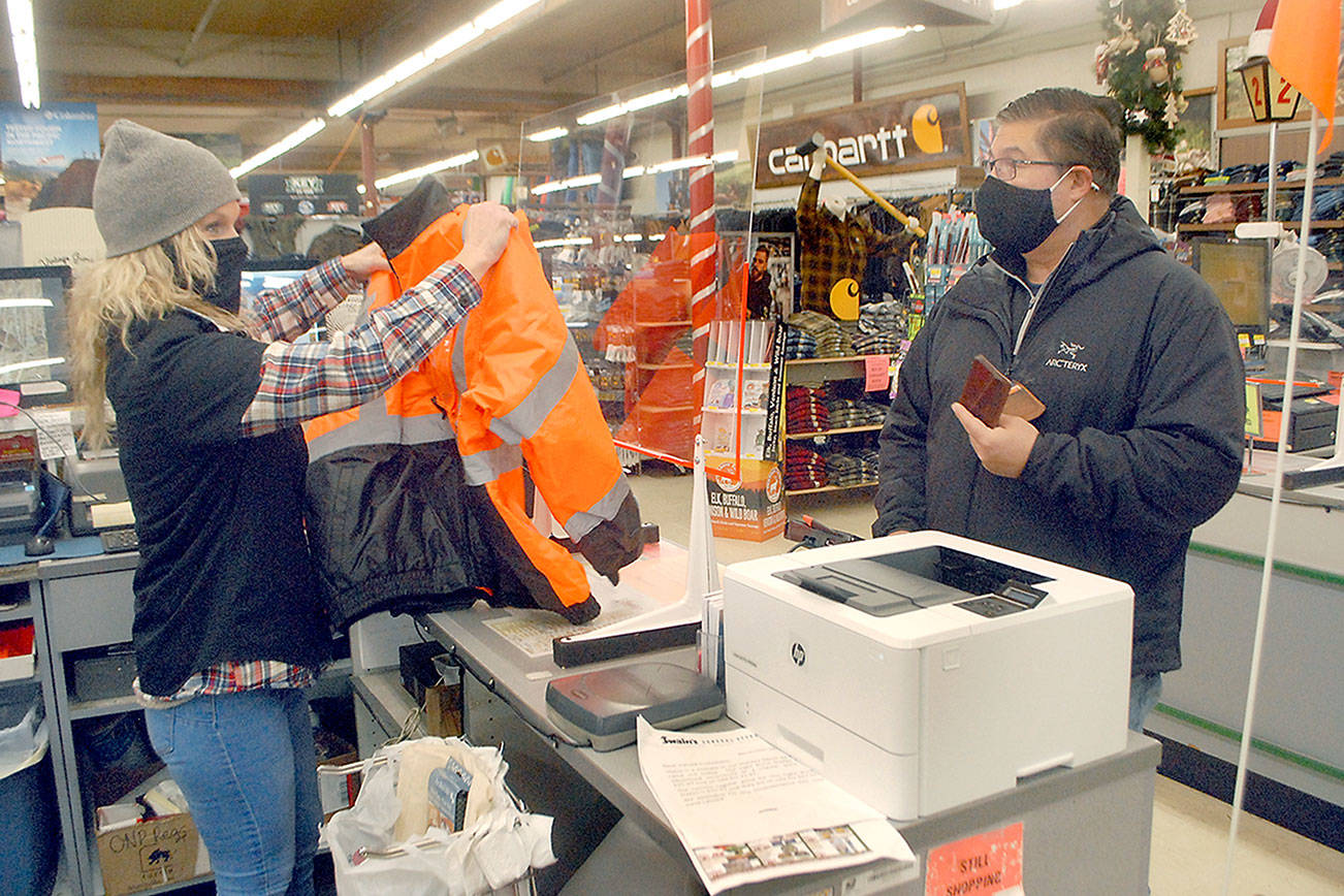 Keith Thorpe/Peninsula Daily News
Swain's General Store employee Farrah Springfield, left, assists customer Mauricio Pena of Port Angeles with a purchase on Saturday in Port Angeles.