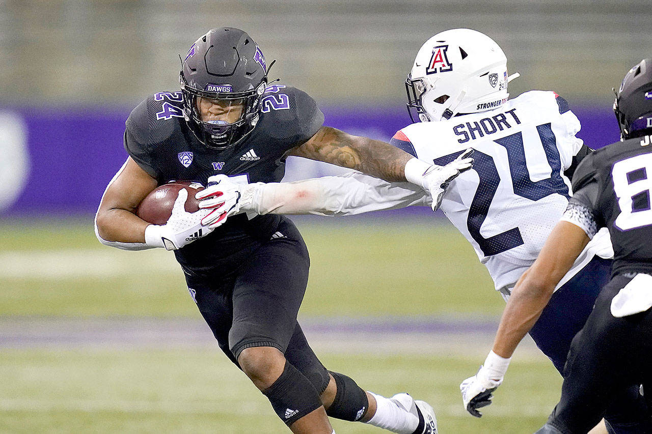 Washingtons Kamari Pleasant, left, pushes away Arizonas Rhedi Short on Pleasants 21-yard touchdown run during the second half Saturday in Seattle. (AP Photo/Elaine Thompson)