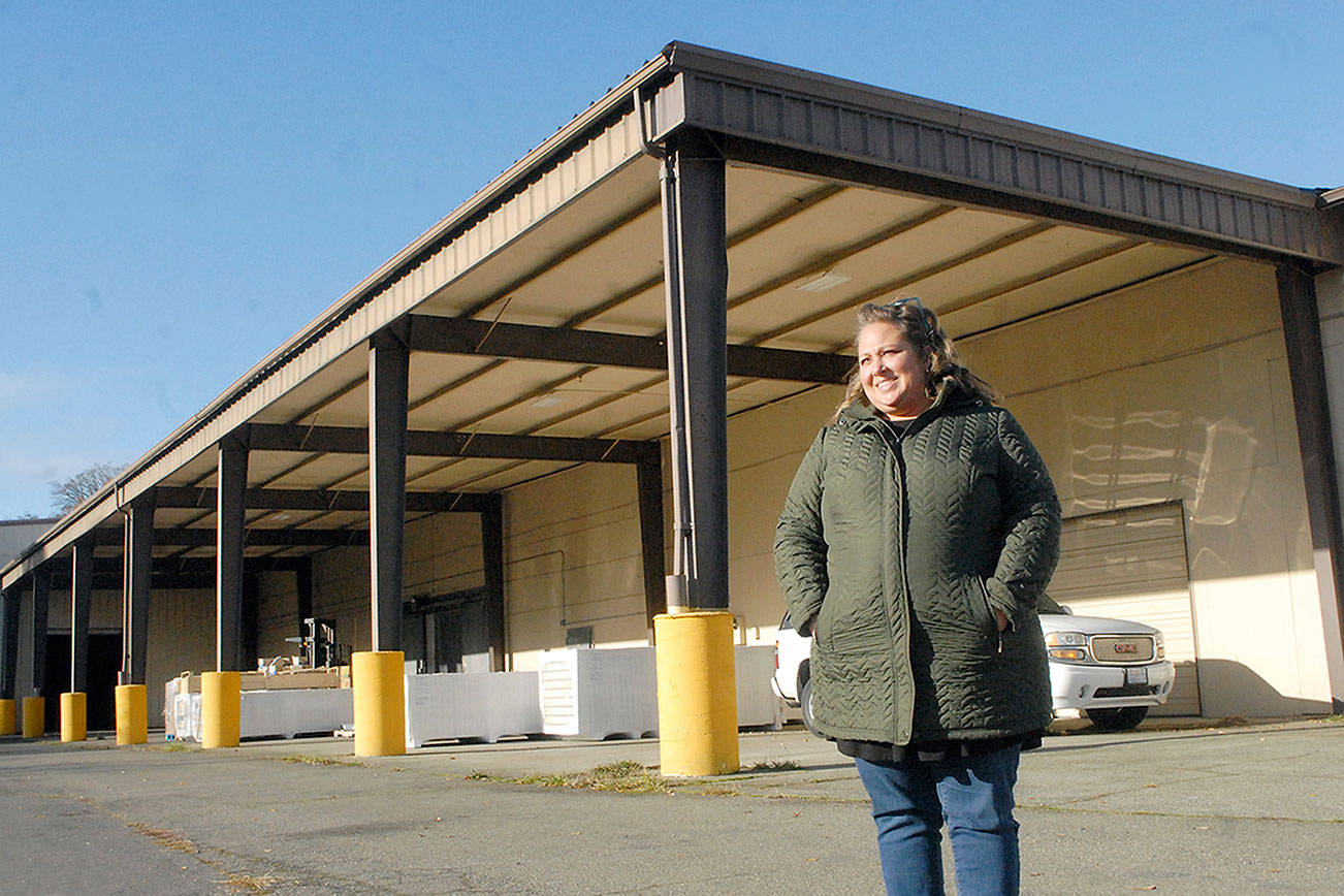 Port Angeles Food Bank Executive Director Emily Dexter stands outside the food bank's new warehouse and distribution center at 632 N. Oakridge Drive near the Port Angeles Walmart. The covered canopy area will become the food bank's drive-thru distribution lane. (Keith Thorpe/Peninsula Daily News)