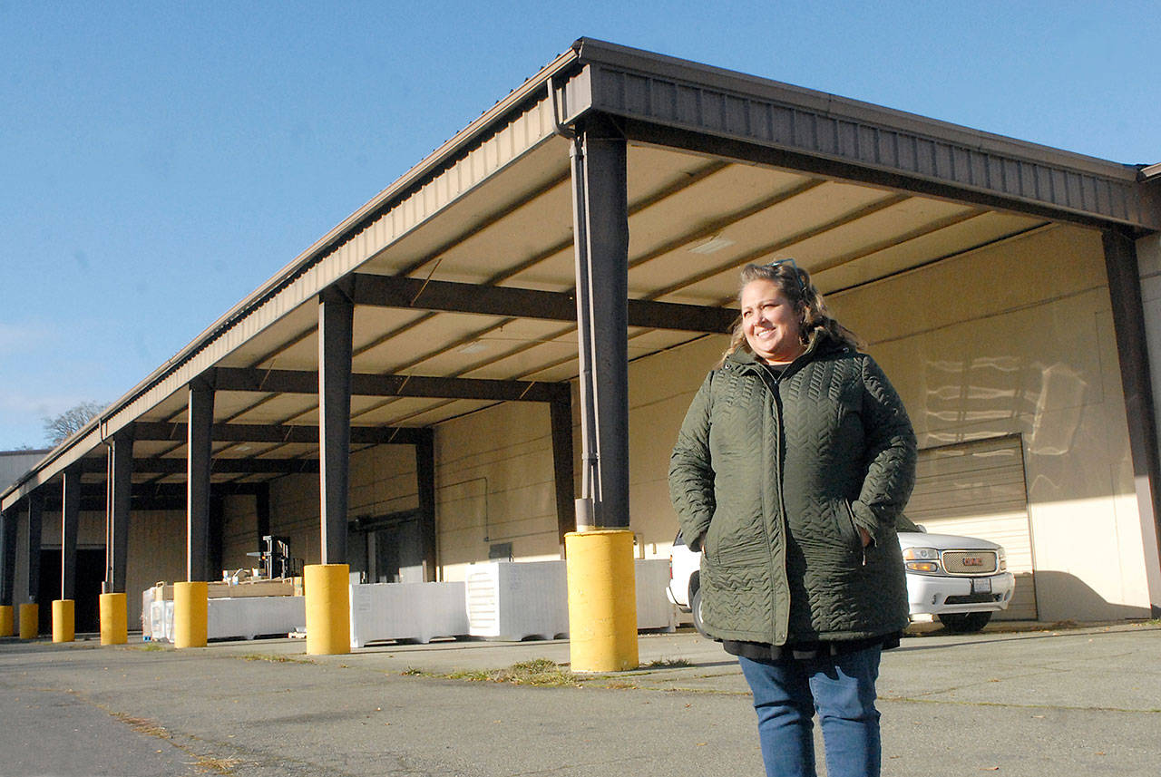 Port Angeles Food Bank Executive Director Emily Dexter stands outside the food bank’s new warehouse and distribution center at 632 N. Oakridge Drive near the Port Angeles Walmart. The covered canopy area will become the food bank’s drive-thru distribution lane. (Keith Thorpe/Peninsula Daily News)