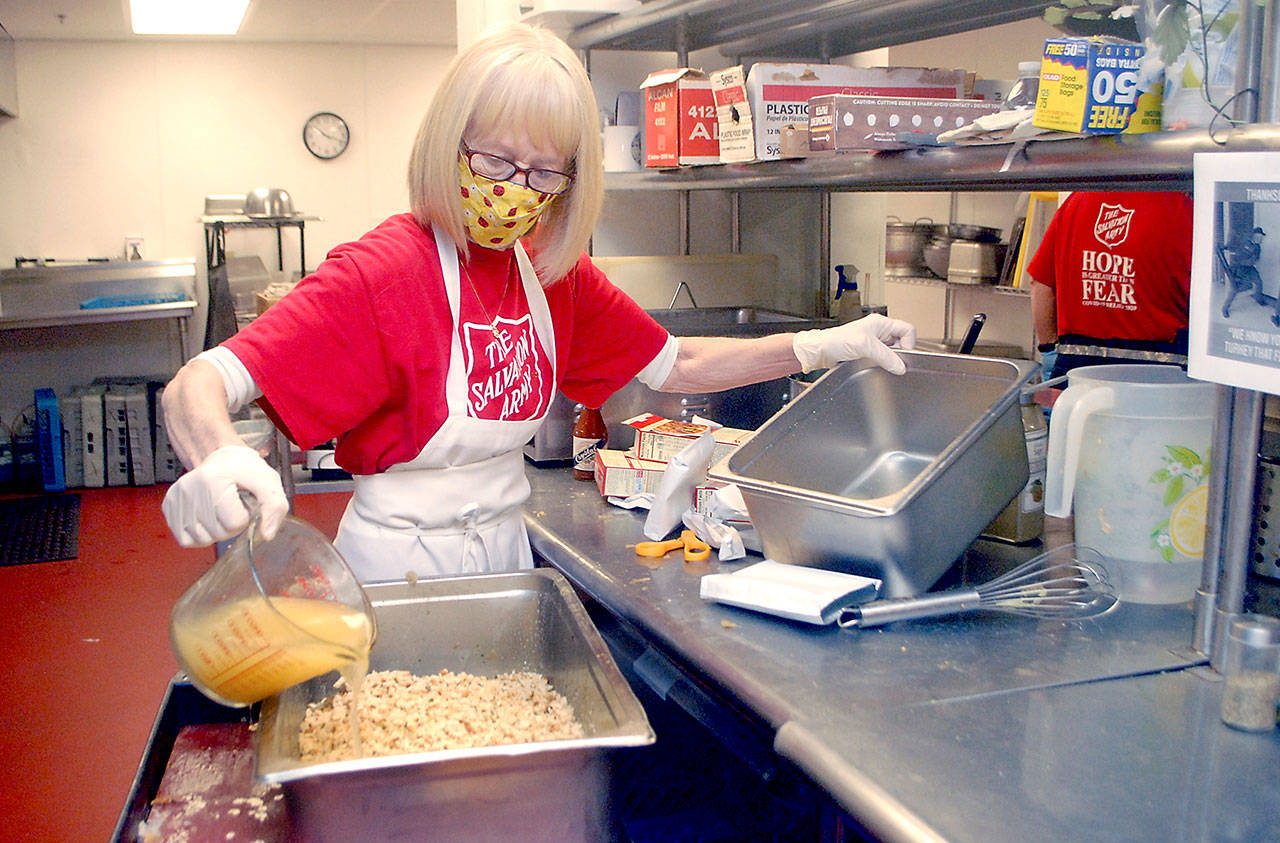 Volunteer Phyllis Meyer of Sequim adds broth to make stuffing for Wednesday’s traditional Thanksgiving Eve lunch at the Port Angeles Salvation Army. (Keith Thorpe/Peninsula Daily News)