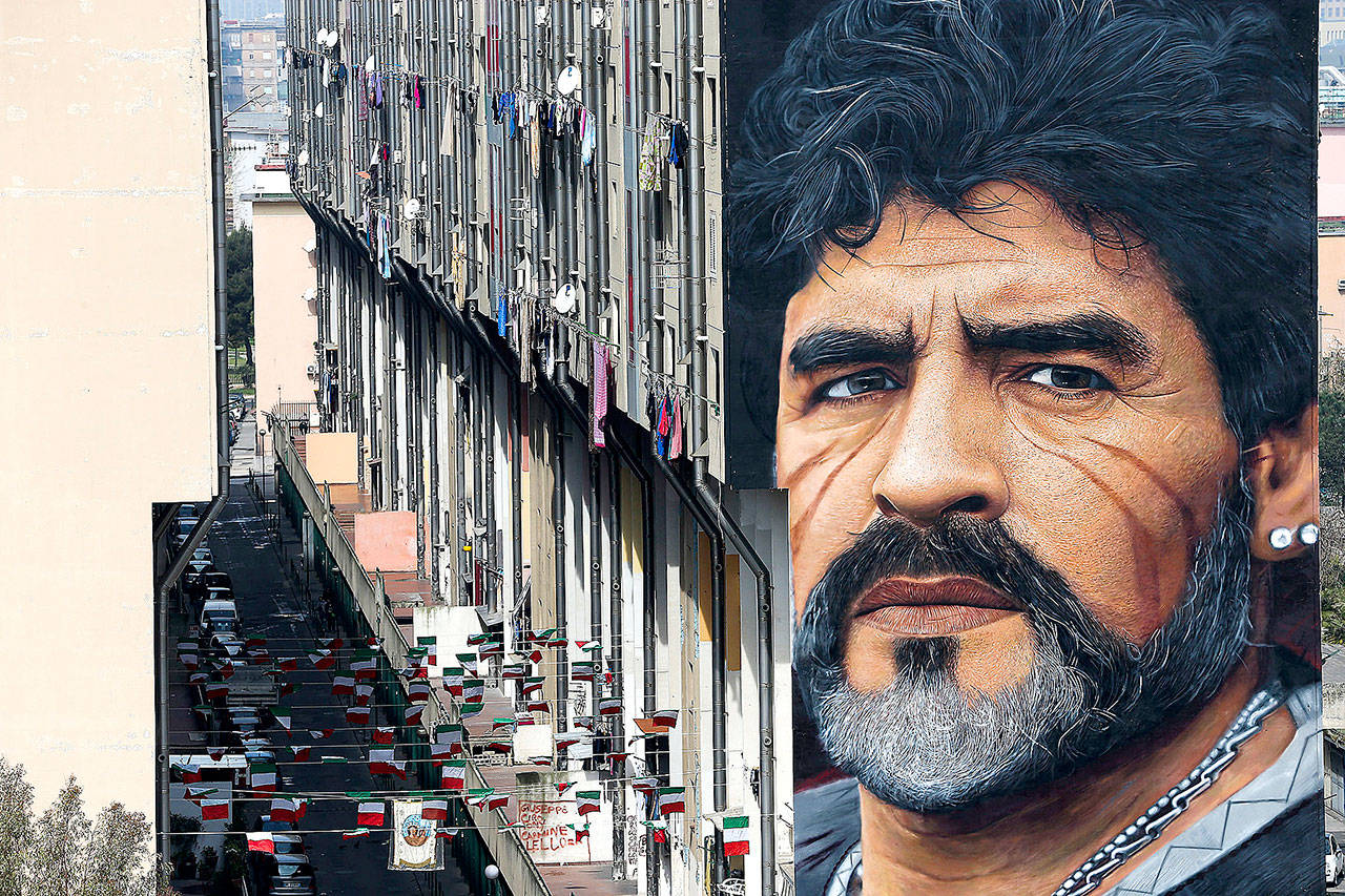 A mural depicting Diego Maradona, by street artist Jorit, is painted on a building in Naples, Italy, March 24, 2017. Diego Maradona has died. The Argentine soccer great was among the best players ever and who led his country to the 1986 World Cup title before later struggling with cocaine use and obesity. He was 60. (Marco Cantile/LaPresse via AP)