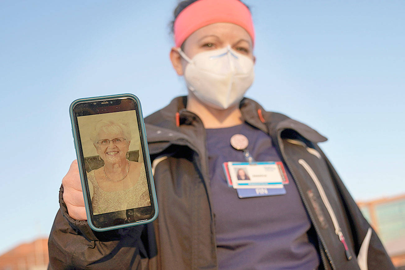 Nurse Jessica Franz, shows a photo of her mother-in-law, Elaine Franz, outside Olathe Medical Center after working the graveyard shift Thursday, Nov. 26, 2020, in Olathe, Kan. Elaine Franz died Nov. 10, one day before her 78th birthday, after contracting COVID-19. (AP Photo/Charlie Riedel)